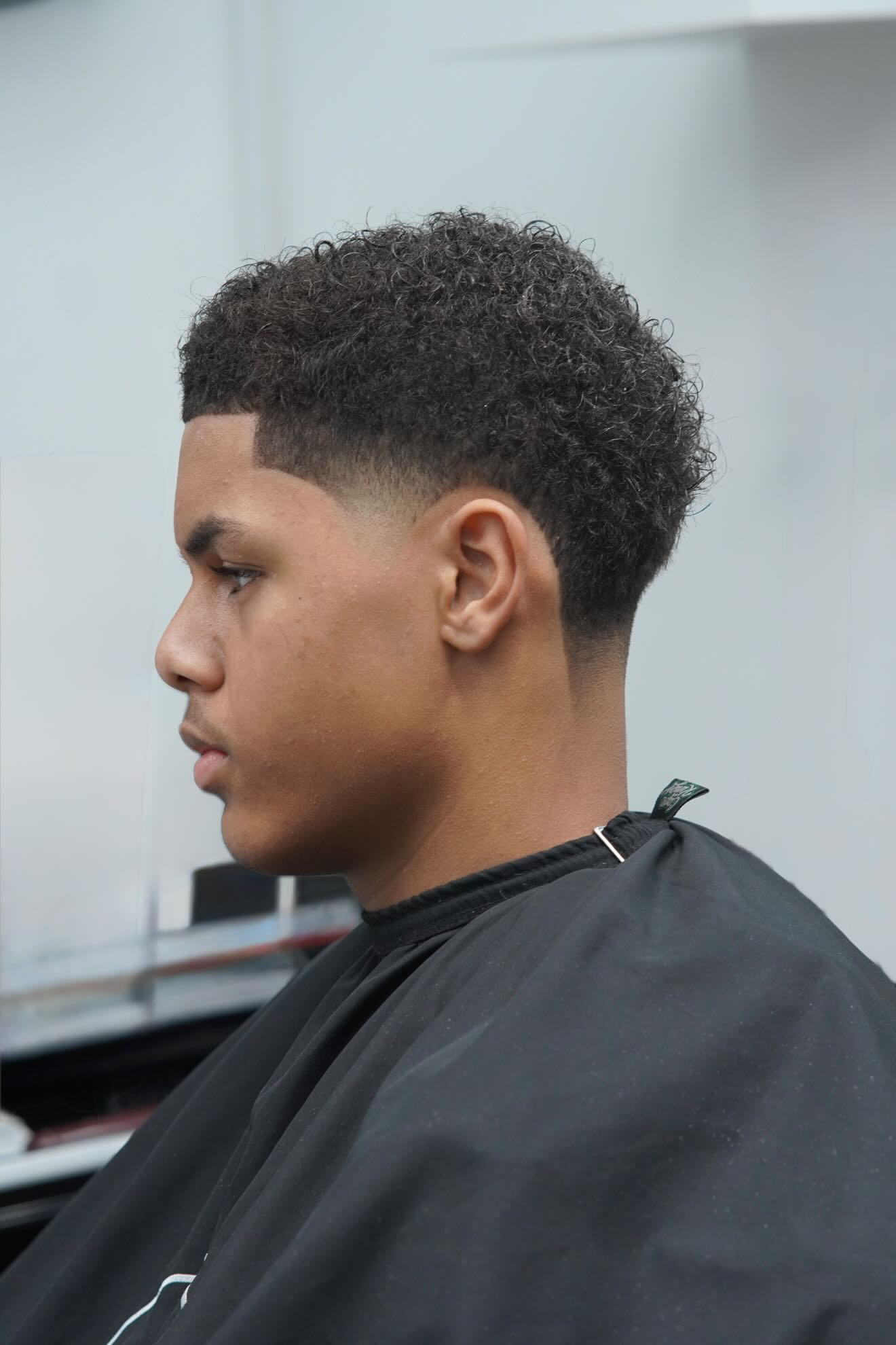 Curly top with taper fade at PB Barbers